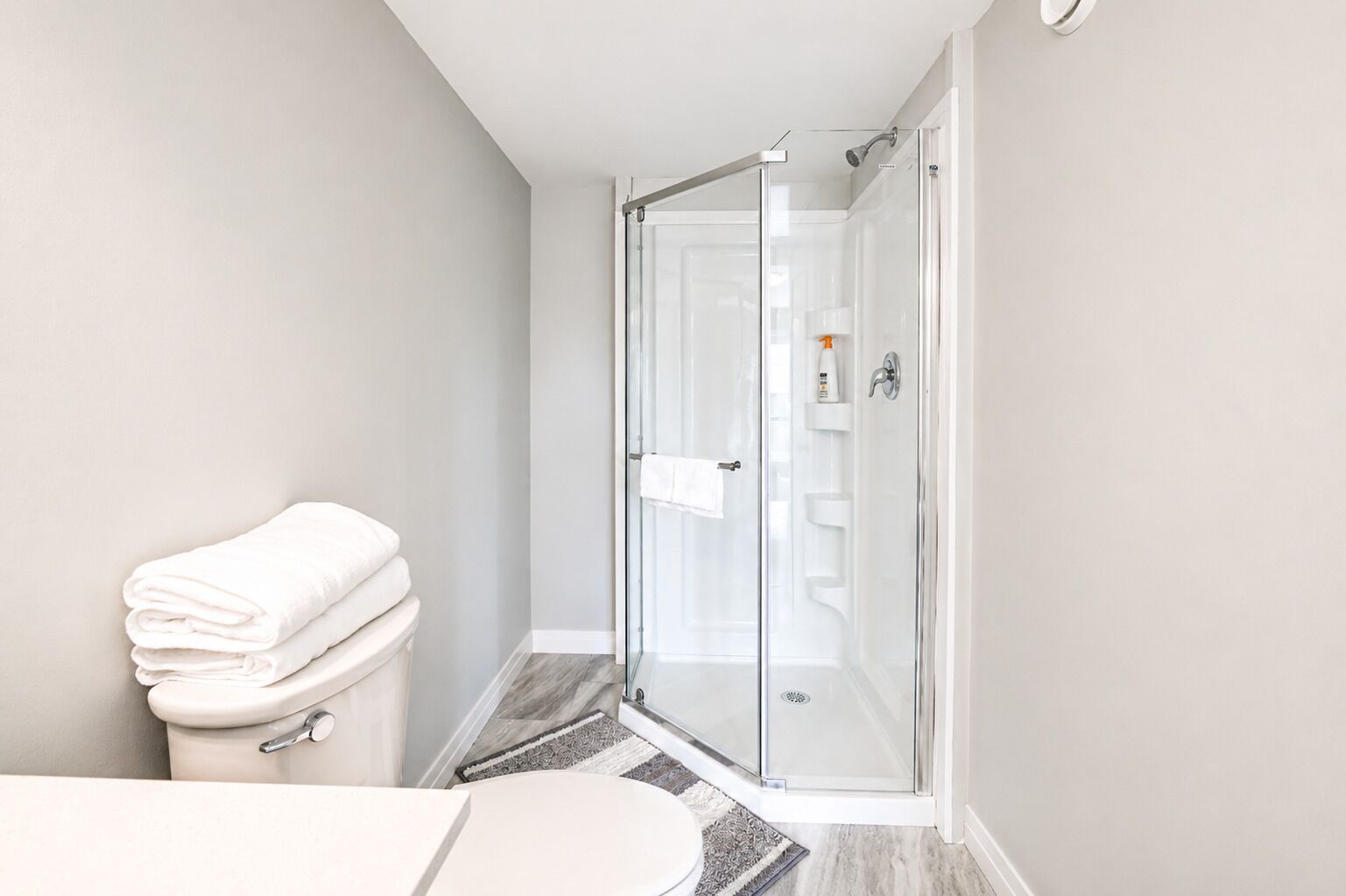 Une salle de bain moderne avec une douche à parois de verre, des toilettes et un lavabo.