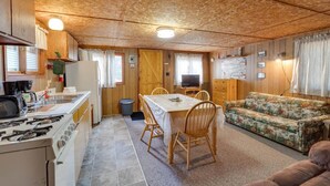 Interior compacto de autocaravana con kitchenette, comedor y sala de estar.