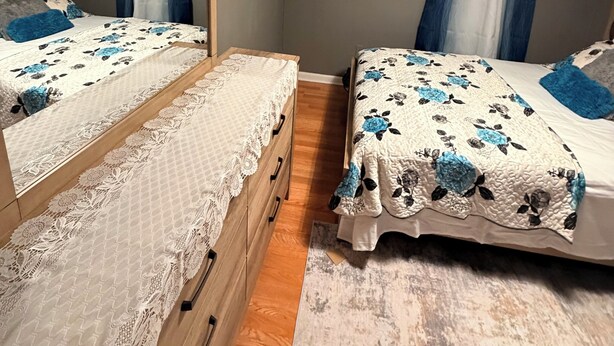 A bedroom with two beds, a wooden dresser, and a mirror. - Cozy 1-bedroom house in welcoming Bridgeport (Bridgeport)