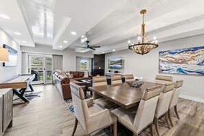 A modern living room with a fireplace, a dining area with a large table, and a sofa. - Elegant Avon Center Condo I Walk to gondola (Avon)