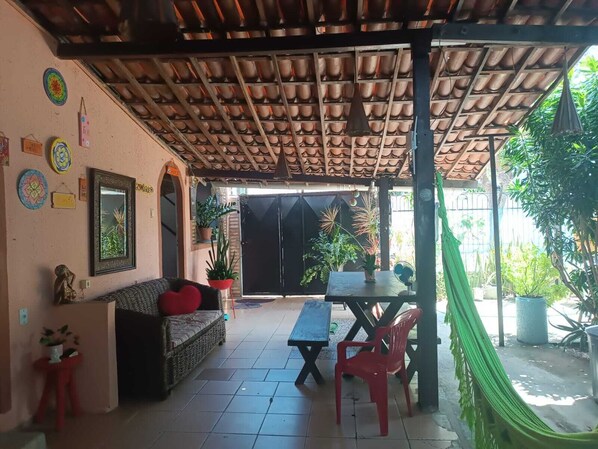 Un patio abrité comprenant un canapé, des chaises, une table et des plantes en pot.