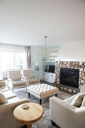Olohuone, jossa on takka, televisio ja kattokruunu.