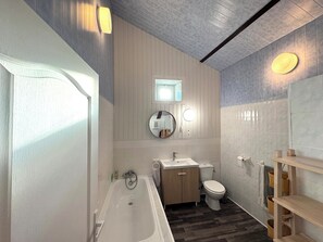Une salle de bain moderne avec une baignoire, des toilettes et un meuble-lavabo.