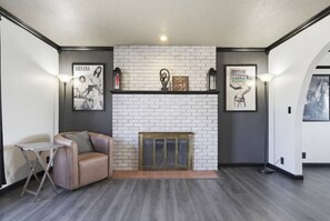 Ein modernes Wohnzimmer mit Kamin, einer Couch und einem kleinen Tisch.