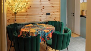 A dining area with a wooden ceiling, a chandelier, and a table with chairs. - Seturebi Wooden House near Gudauri 2 (Seturni)