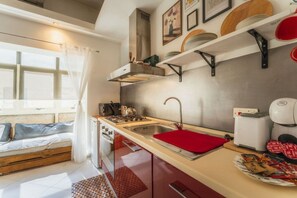 A compact kitchen with a gas stove, sink, and a coffee machine. - Stylish Apartment | 1BR Near Sliema & Valletta (Gżira)