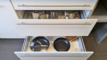 A kitchen drawer with pots and pans.
