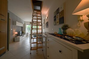 A kitchen with a wooden ladder, white cabinets, a dining area, and a view to the outside. - Venus Re near Cuvi Rovinj (rovinj)