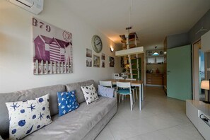 A living room with a sofa, dining table, chairs, a kitchen area, and a hallway. - Venus Re near Cuvi Rovinj (rovinj)