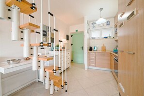 A kitchen with white cabinets, a green door, and a hanging light fixture. - Venus Re near Cuvi Rovinj (rovinj)