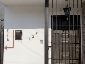 A gated entrance with a number '125' and a fire alarm box. - Mini loft junto a la UDEM (San Pedro Garza García)