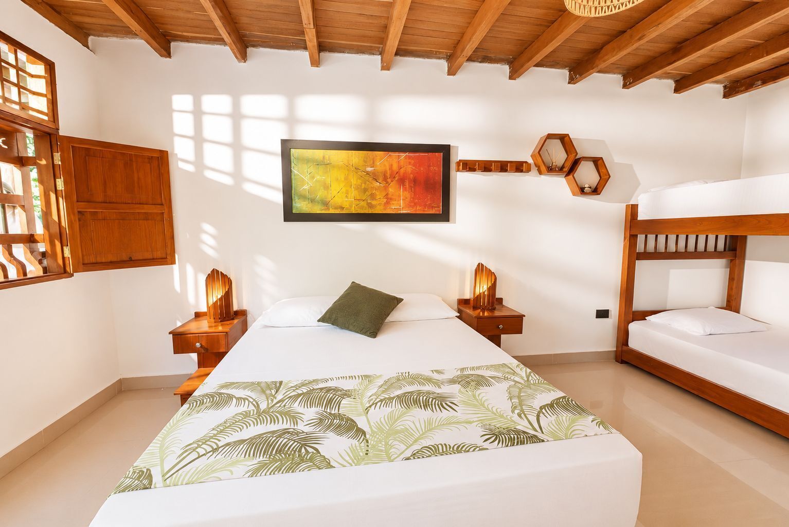 A bedroom with a bed, a bunk bed, wooden beams, a painting, and a window with natural light.