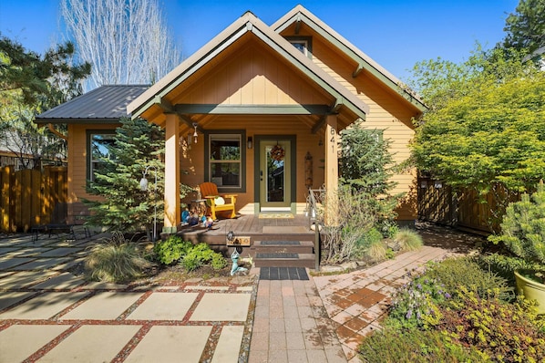 A house with a front porch, a covered entryway, and a small garden area. - Bluebird Day - Desert Zen in Bend with 2 queens, fenced yard, fireplace, Walk Everywhere! (Bend)