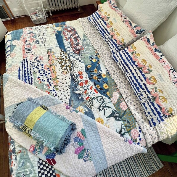 A bed with a quilt featuring various patterns and colors. - Studio w Parking in Portsmouth Historic District (Portsmouth)