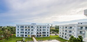 Ein modernes Mehrstöckhotel mit Balkonen, einem gepflegten Rasen und freiem Blick auf die umliegende Landschaft.