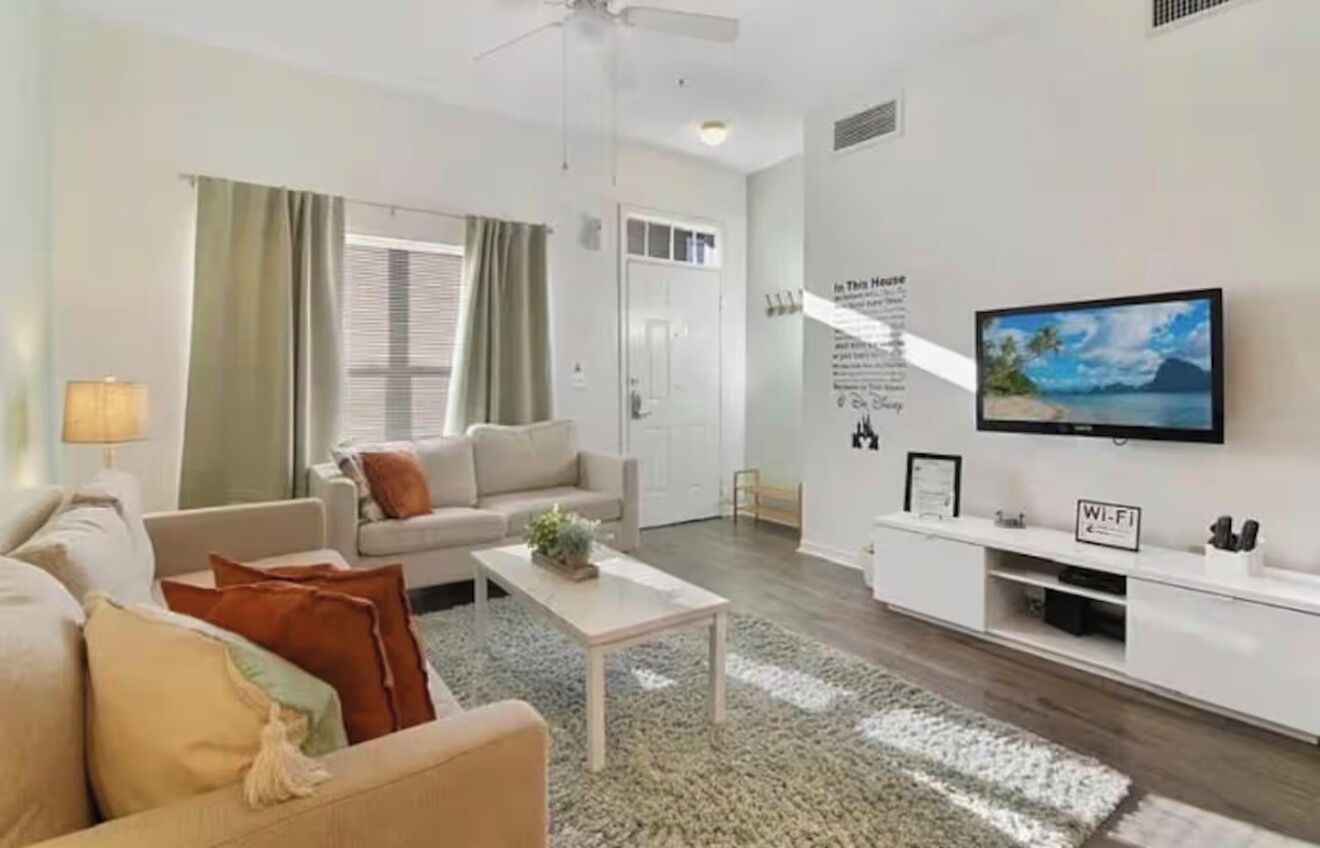 Un salon moderne avec un canapé, une table basse et un téléviseur.