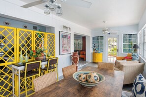 A dining area with a wooden table, yellow chairs, and a yellow partition.
