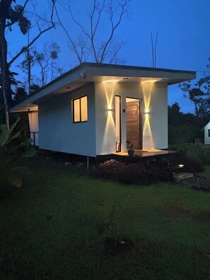 A modern house with a flat roof, a front door, and two windows. - 🌿 Private Getaway in La Fortuna -Bungalows Jacuzzi, River and Nature ✨ 20 min. (Fortuna)