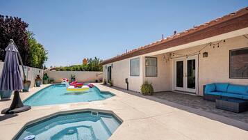 Ein Garten mit Pool, Whirlpool und Sitzbereich im Freien.