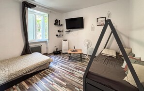 Ein Zimmer mit einem Bett, einem Schreibtisch, einem Stuhl, einem Fernseher und einem Fenster.