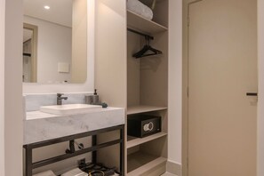 A bathroom with a mirror, two sinks, a towel rack, and a storage unit. - Hotel Mandu (Teresina)