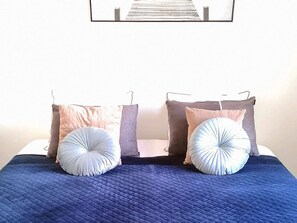 A bed with a blue quilt, two pillows, and a wall-mounted picture. - 4 Star Holiday Home in Aabenraa (Aabenraa)