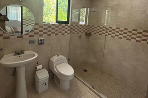 A bathroom with a sink, toilet, and shower.