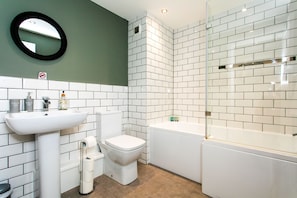 A bathroom with a sink, toilet, and bathtub, all in white. - 198 Portland Apartments by Rizalina (Newcastle upon Tyne)