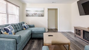 Una sala de estar con un sofá seccional, una mesa de centro y una chimenea.