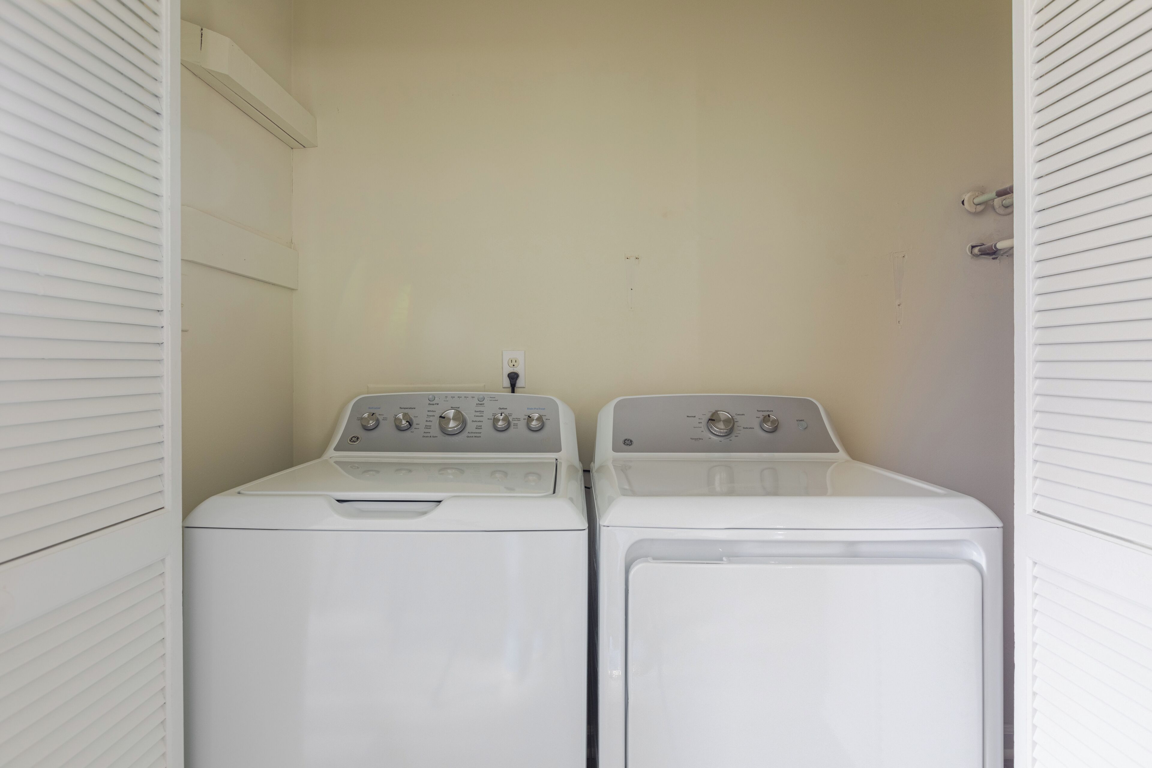 A laundry room with two white front-loading washing machines.