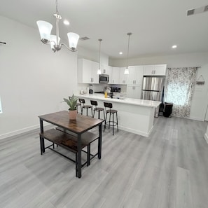 A modern kitchen with white cabinets, stainless steel appliances, and a central island. - New Construction 3-bedroom house in vibrant Houston (Houston)