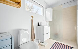 Ein modernes Badezimmer mit Toilette, Waschbecken und Dusche.