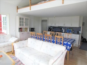 A compact living space with a dining area, kitchenette, and a sofa. - Panoramic sea-view from the house (Bräkne-Hoby)