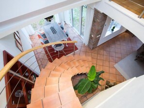 Un escalier en colimaçon offrant une vue sur un coin repas et une plante.