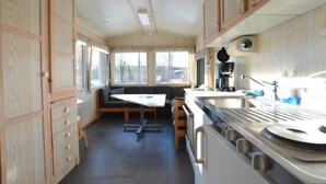Une cuisine de taille réduite, équipée d’une cuisinière, d’un évier et de meubles de rangement en bois.
