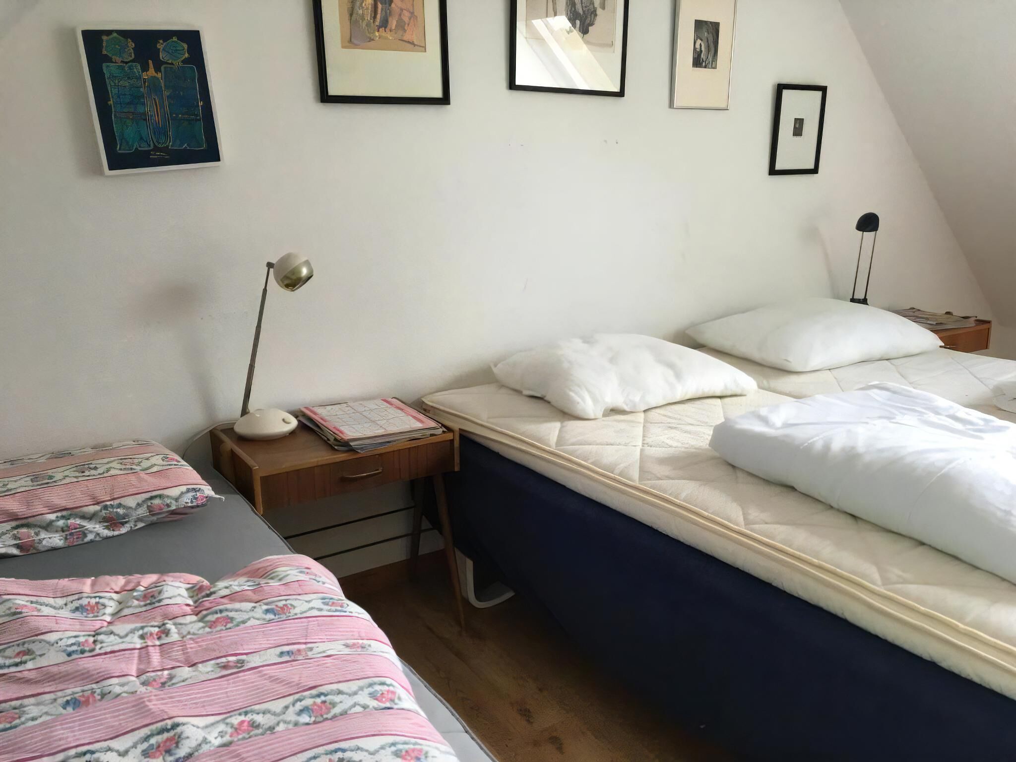 A bedroom with a bed, two bedside tables, a desk, and a chair.