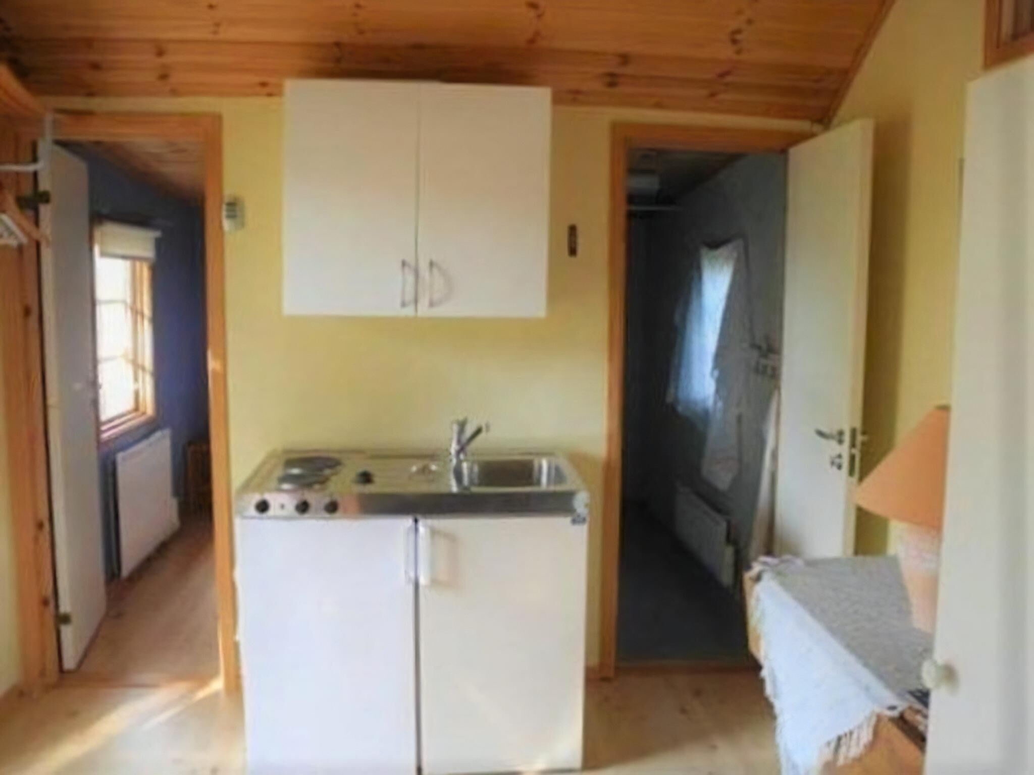 A compact kitchen with a stove, sink, and a white refrigerator.