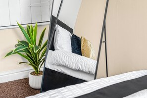 A bed with a white and black bedspread, a potted plant, and a window with blinds. - NEW! 3BR House, free on-street parking, near Nottingham City Centre (Nottingham)