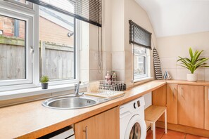 A kitchen with a washing machine, a sink, and a window with blinds. - NEW! 3BR House, free on-street parking, near Nottingham City Centre (Nottingham)