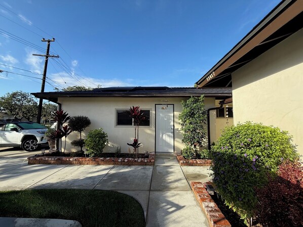 A single-story house with a front door, a small porch, and a driveway. - Lakewood CA 3BR Home w/ Pool & Jacuzzi – 30+ Day Rentals (Lakewood)