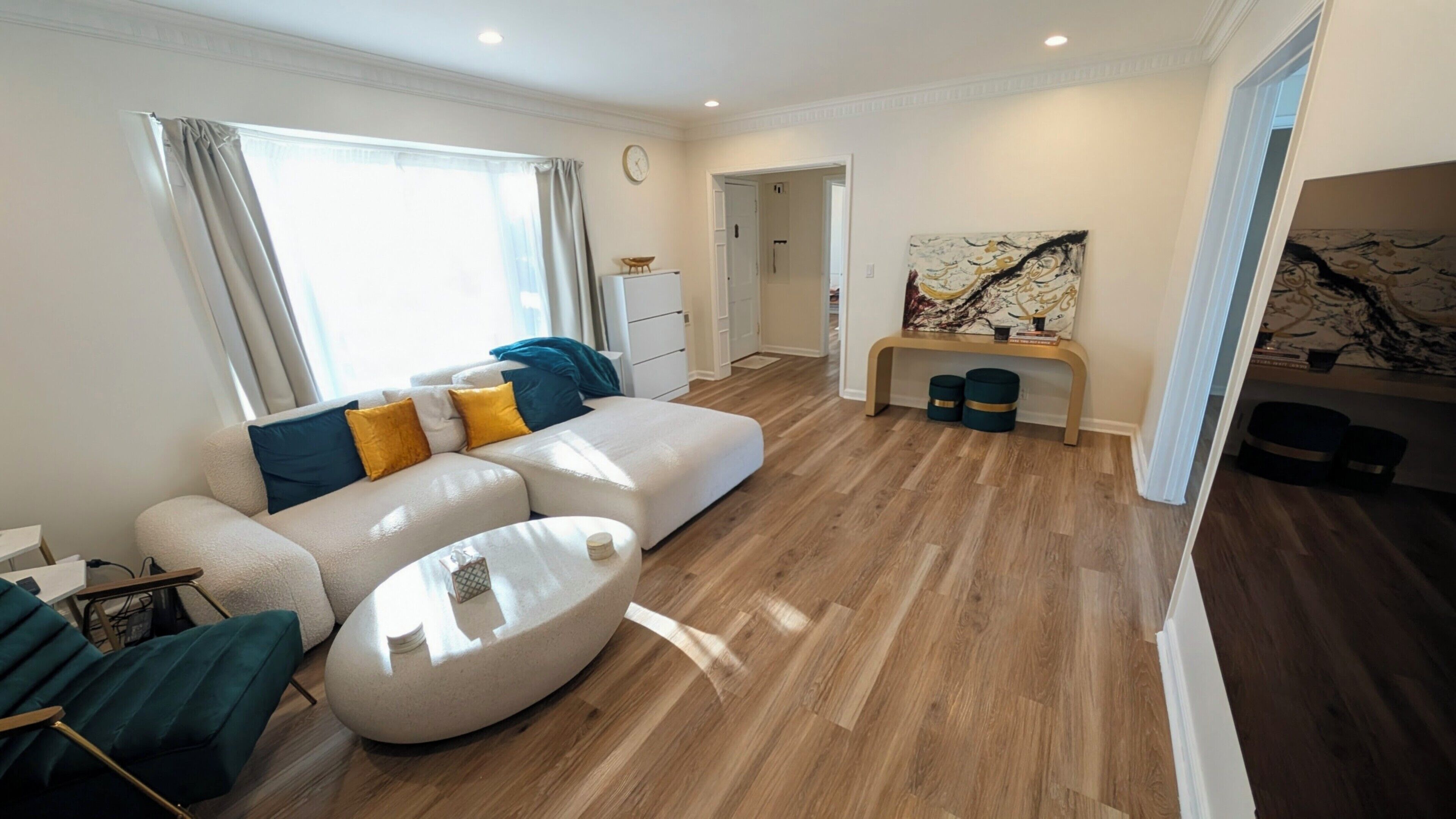 A modern living room with a sectional sofa, a round coffee table, and a dining area with a bench.