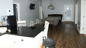 A room with a kitchen area, a dining table, and a pool table. - Luxury Retreat 20 Minutes from downtown- heated pool (Stockbridge)