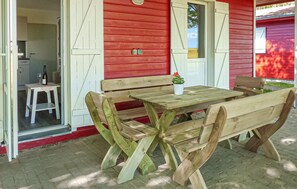 An outdoor wooden bench and table set against a red building with a door and window. - Nice home in Barth with house a panoramic view (Barth)