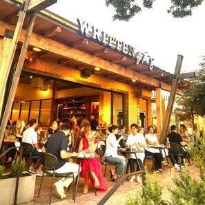 Ein Sitzbereich im Freien eines Restaurants mit einer Holzfassade und der Beschriftung 'WRITEN'.