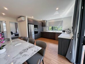 Een moderne keuken met een marmeren aanrechtblad, inbouwapparatuur en uitzicht op de omgeving.