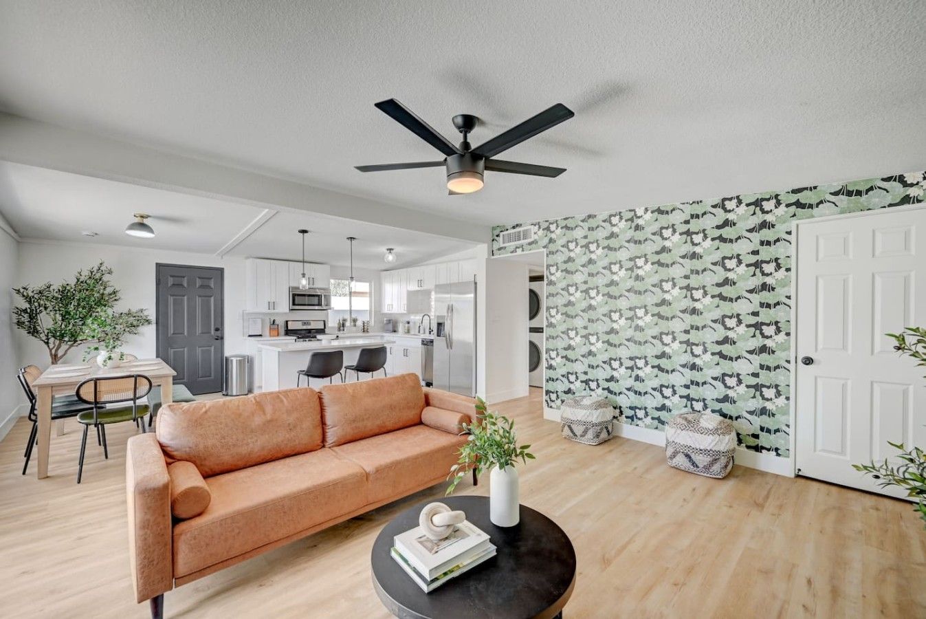 A modern living room with a sofa, a coffee table, and a ceiling fan.