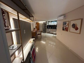 Eine moderne Küche mit weißen Schränken, einem Edelstahlkühlschrank und einem Essbereich mit Holztisch und Stühlen.