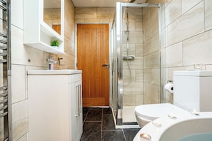 Un baño con ducha, inodoro y lavamanos.