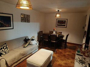 A compact living space with a sofa, a dining table with chairs, and a small kitchenette area. - Apartment in Lima with transfer included (Santiago de Surco)