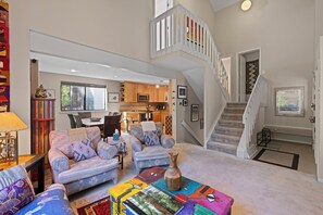 Ein geräumiges Wohnzimmer mit einer Sofagarnitur, einem Couchtisch und einer Treppe zu einer oberen Ebene.